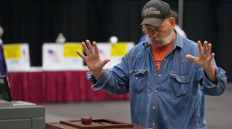 A Mainer reacts after his papers successfully dropped into to a ballot box while voting in the Maine Primary, Tuesday, June 9, 2026, in Augusta, Maine. (AP Photo/Robert F. Bukaty)