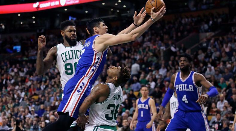 Philadelphia 76ers forward Ersan Ilyasova collides with Boston Celtics guard Marcus Smart (36) on a drive to the basket during the second half of an NBA basketball game in Boston, Wednesday, Feb. 15, 2017. The Celtics defeated the 76ers 116-108. (AP Photo/Charles Krupa)