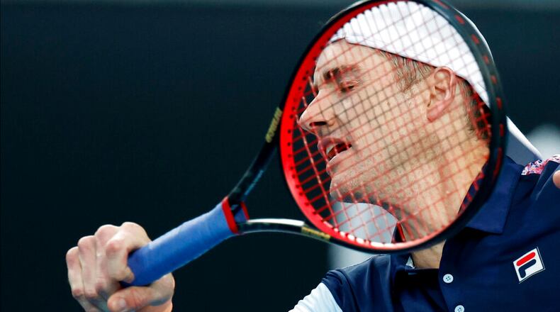 John Isner of the U.S. plays a forehand return to Adrian Mannarino of France during their first round match at the Australian Open tennis championship in Melbourne, Australia, Wednesday, Jan. 18, 2023. (AP Photo/Asanka Brendon Ratnayake)