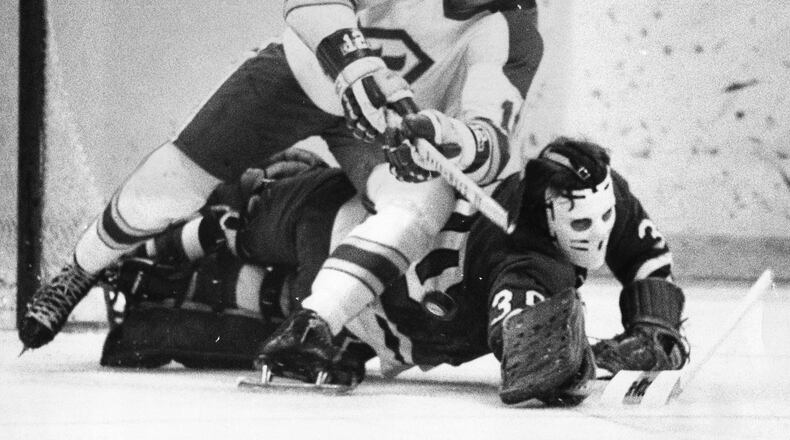 Tom Lysiak (top) of the Flames crashes into the Blackhawks' goalie while trying to score. AJC file photo.