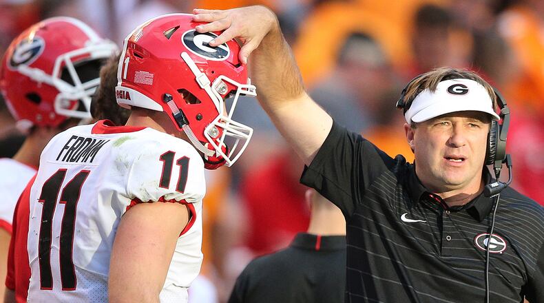 Kirby Smart gives quarterback Jake Fromm a pat on the helmet after his second touchdown run against Tennessee Saturday, Sept. 30, 2017, in Knoxville, Tenn.