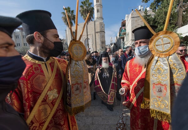 FILE -Greek Orthodox Patriarch of Jerusalem Theophilos III, center, arrives for Christmas celebrations, according to the Eastern Orthodox calendar, outside the Church of the Nativity, traditionally recognized by Christians to be the birthplace of Jesus Christ, in the West Bank city of Bethlehem, Jan. 6, 2021. (AP Photo/Nasser Nasser), File)