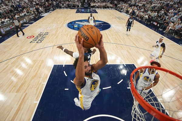 Golden State Warriors forward Trayce Jackson-Davis (32) goes up for a dunk as Minnesota Timberwolves center Naz Reid (11), back, defends during the second half of Game 2 of an NBA basketball second-round playoff series, Thursday, May 8, 2025, in Minneapolis. (AP Photo/Abbie Parr)
