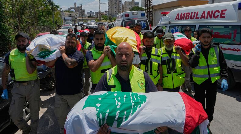 Mourners and paramedics carry the bodies of family members killed on Wednesday when their car was struck in an Israeli airstrike on a highway as they fled their village, during a funeral procession in the southern port city of Tyre, Lebanon, Friday, May 29, 2026. (AP Photo/Mohammed Zaatari)