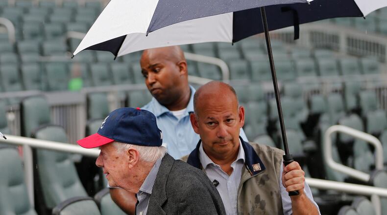 Former President Jimmy Carter leaves his seat as rain begins to fall before a baseball game between the Chicago Cubs and the Atlanta Braves on Tuesday in Atlanta. AP /John Bazemore