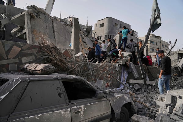 Palestinians search for survivors amid the debris of a building destroyed by an Israeli airstrike in Deir al-Balah, Gaza Strip, on Monday, April 7, 2025. (AP Photo/Abdel Kareem Hana)