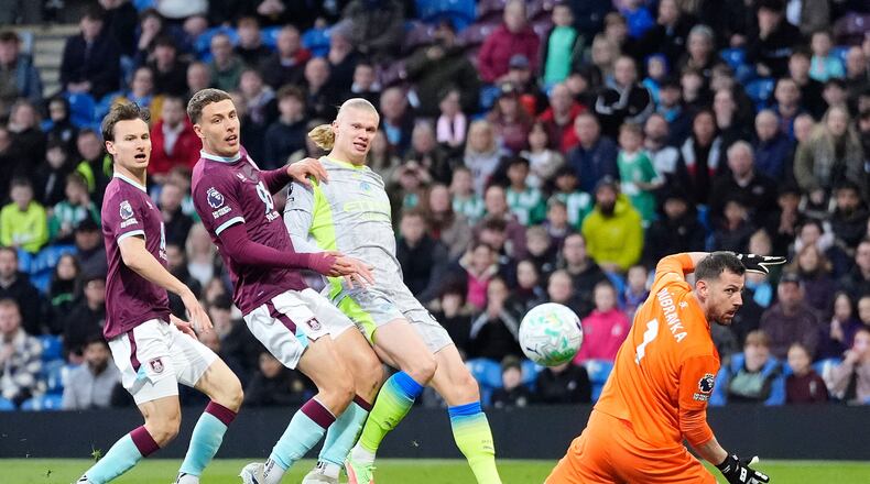 Manchester City's Erling Haaland, second right, scores his side's opening goal during the Premier League soccer match between Burnley and Manchester City in Burnley, England, Wednesday, April 22, 2026. (Nick Potts/PA via AP)