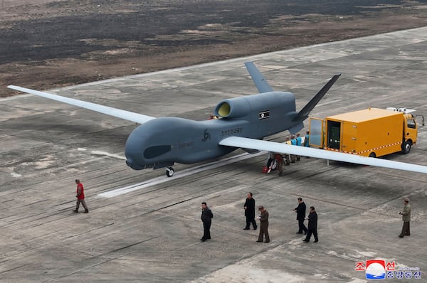 In this photo provided Thursday, March 27, 2025, by the North Korean government, its leader Kim Jong Un, center bottom, walks by what appeared to be a large reconnaissance drone at an undisclosed location in North Korea, earlier this week. Independent journalists were not given access to cover the event depicted in this image distributed by the North Korean government. The content of this image is as provided and cannot be independently verified. Korean language watermark on image as provided by source reads: "KCNA" which is the abbreviation for Korean Central News Agency. (Korean Central News Agency/Korea News Service via AP)