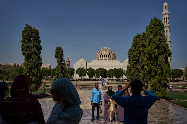 Tourists walk through the courtyard of the Sultan Qaboos Grand Mosque in Muscat, Oman, Saturday, April 12, 2025. (AP Photo/ Fatima Shbair)