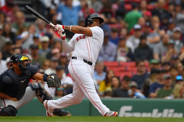 Boston Red Sox's Rafael Devers, right, follows through on his swing after hitting a grand slam in front of Atlanta Braves catcher Drake Baldwin, left, in the third inning of a baseball game, Sunday, May 18, 2025, in Boston. (AP Photo/Steven Senne)