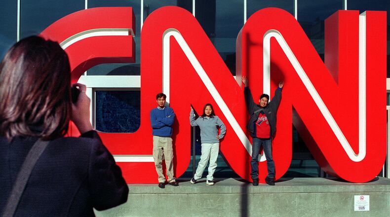 Visitors take a souvenir photo at the CNN sign outside CNN Center in 1999. (AJC File).