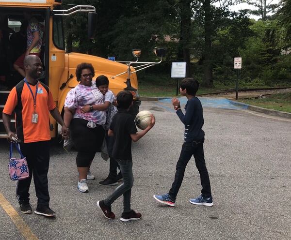 Students greet staffers from the International Community School Wednesday at Milam Park in Clarkston. The students live in Clarkston, but the school is in Decatur. Principal Chad Velde-Cabrera said it was important for his staff to know the community where their students live. (MARLON A. WALKER / marlon.walker@ajc.com)
