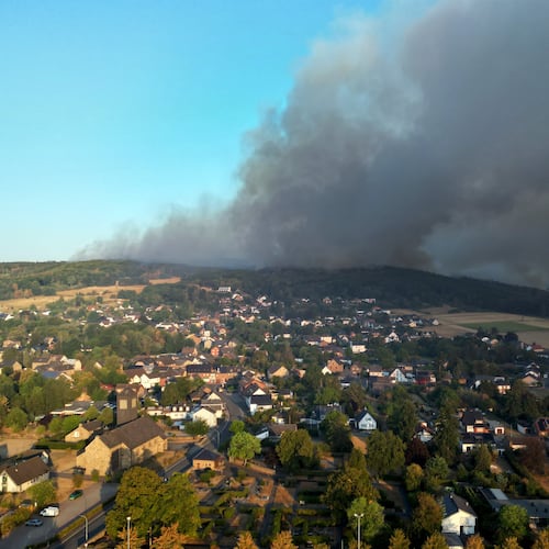 Thick smoke drifts over the Gey district from a forest fire in Hürtgenwald, Germany, Friday, Aug. 14, 2026. (Federico Gambarini/dpa via AP)