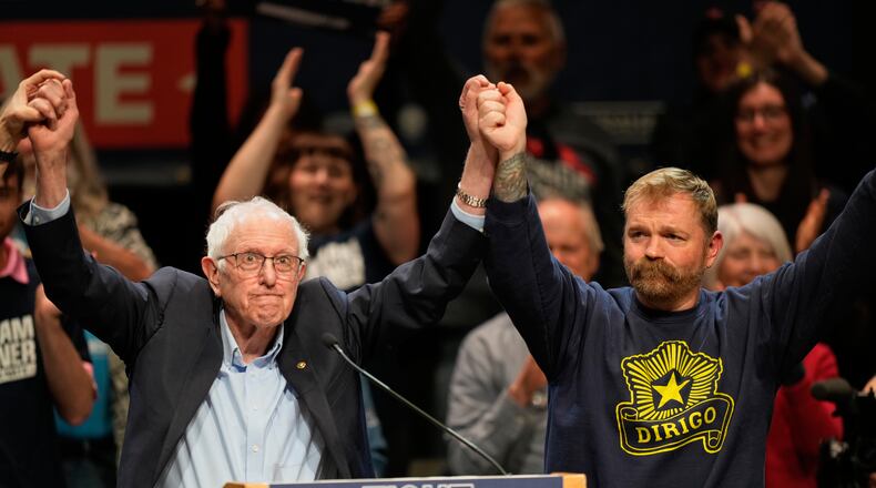FILE - Graham Platner, Democratic candidate for U.S. Senate, and Sen. Bernie Sanders, I-Vt., left, join hands at an event in Orono, Maine, May 24, 2026. (AP Photo/Robert F. Bukaty, File)