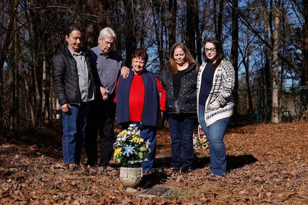 Family members stand at the gravesite of Herman Wilder in Gainesville. Gene Odom and his wife Cheryl (left) are joined by Wanda Keith (center), Sherri Burt and Brandi Loftin. (Natrice Miller/AJC)