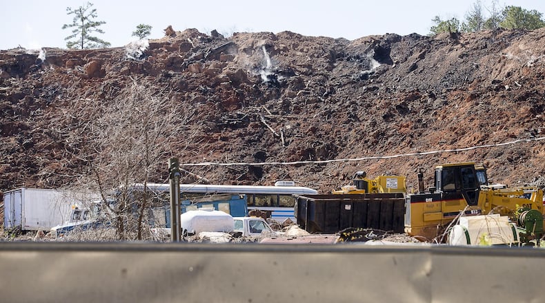 Smoke can be seen rising from an unlicensed landfill, located at 7635 Bishop Road, in South Fulton, Wednesday, Feb. 13, 2019.