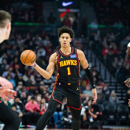 Atlanta Hawks forward Jalen Johnson (1), center, dishes a pass to Atlanta Hawks guard Vit Krejci, left, during the first half of an NBA basketball game against the Portland Trail Blazers on Thursday, Jan. 15, 2026, in Portland, Ore. (AP Photo/Molly J. Smith)