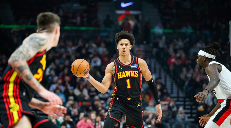 Atlanta Hawks forward Jalen Johnson (1), center, dishes a pass to Atlanta Hawks guard Vit Krejci, left, during the first half of an NBA basketball game against the Portland Trail Blazers on Thursday, Jan. 15, 2026, in Portland, Ore. (AP Photo/Molly J. Smith)