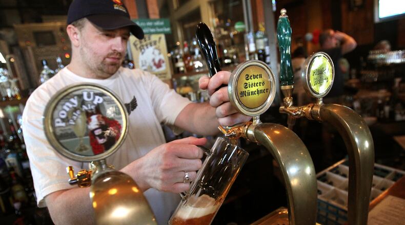 Bartender Rob Locke pours the beer, "Seven Sisters Munchner," from the tap for a customer at 5 Seasons Brewing Company Thursday afternoon in Sandy Springs, Ga., April 5, 2012.