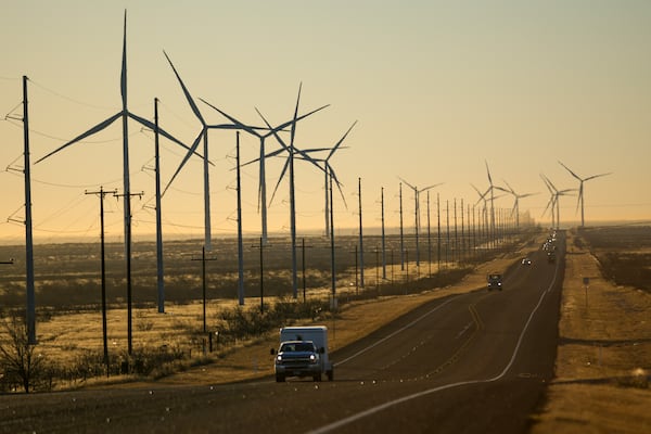 FILE - Wind turbines are visible along Route 176 as vehicles travel eastbound Feb. 24, 2025, in Andrews, Texas. (AP Photo/Julio Cortez, File)