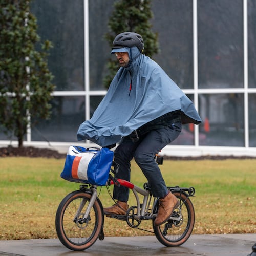 A man rides a bicycle in the rain along 10th Street in downtown Atlanta on Tuesday, Nov. 25, 2025. (Ben Hendren for the AJC)