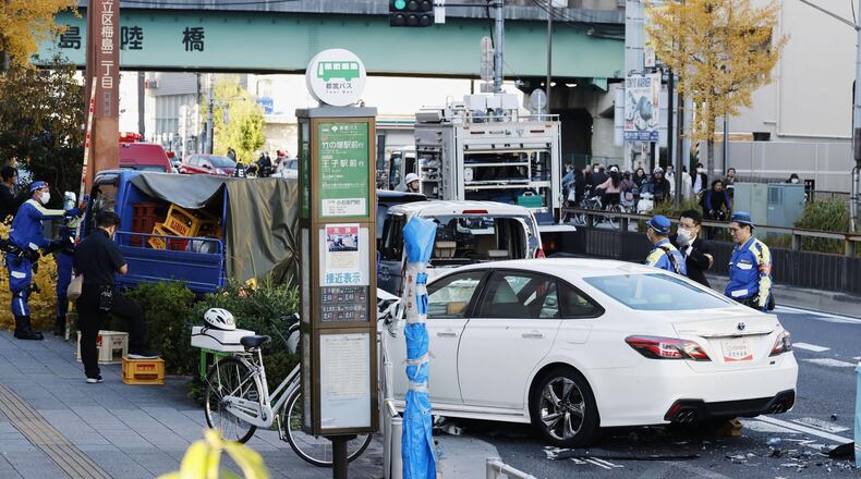 Investigators inspect the scene of a car accident injuring multiple people in Tokyo, Monday, Nov. 24, 2025. (Michi Ono/Kyodo News via AP)
