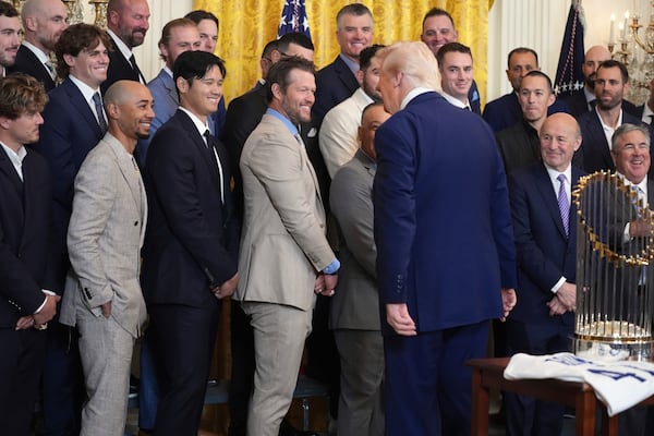 President Donald Trump, in foreground, greets Los Angeles Dodgers' Kiké Hernández, from left, Mookie Betts, Shohei Ohtani and Clayton Kershaw during a ceremony to honor the Major League Baseball 2024 World Series Champions in the East Room of the White House, Monday, April 7, 2025, in Washington. (AP Photo/Evan Vucci)
