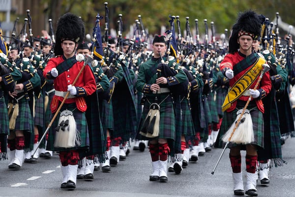 A pipe band marches past thousands of people lining the street to pay tribute to their war dead during the Anzac Day parade in Sydney, Australia, Friday, April 25, 2025. (AP Photo/Rick Rycroft)