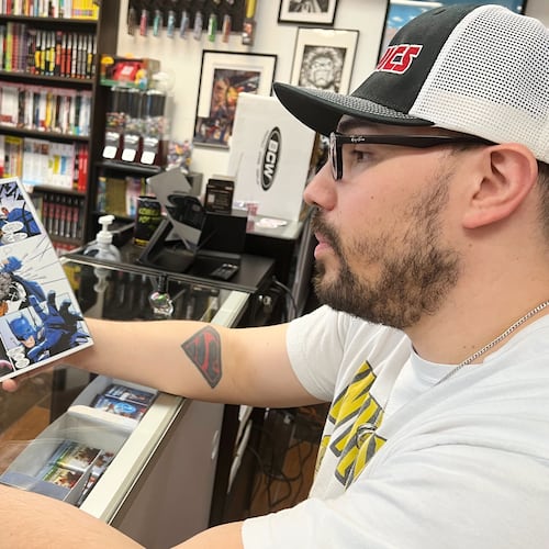 Lecho Lopez shoes comic books at his store JLA Comics on Tuesday, Nov. 18, 2025 in Sacramento, Calif. (AP Photo/Sophie Austin)