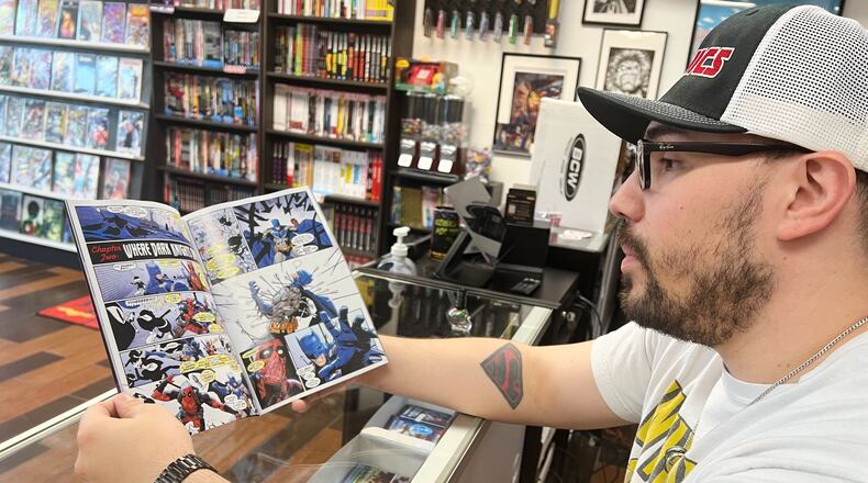 Lecho Lopez shoes comic books at his store JLA Comics on Tuesday, Nov. 18, 2025 in Sacramento, Calif. (AP Photo/Sophie Austin)