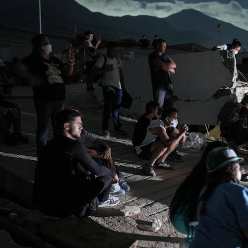 Residents watch rescuers' efforts to reach survivors beneath the rubble of a building that collapsed in the earthquakes in La Guaira, Venezuela, early Monday, June 29, 2026. (AP Photo/Matias Delacroix)