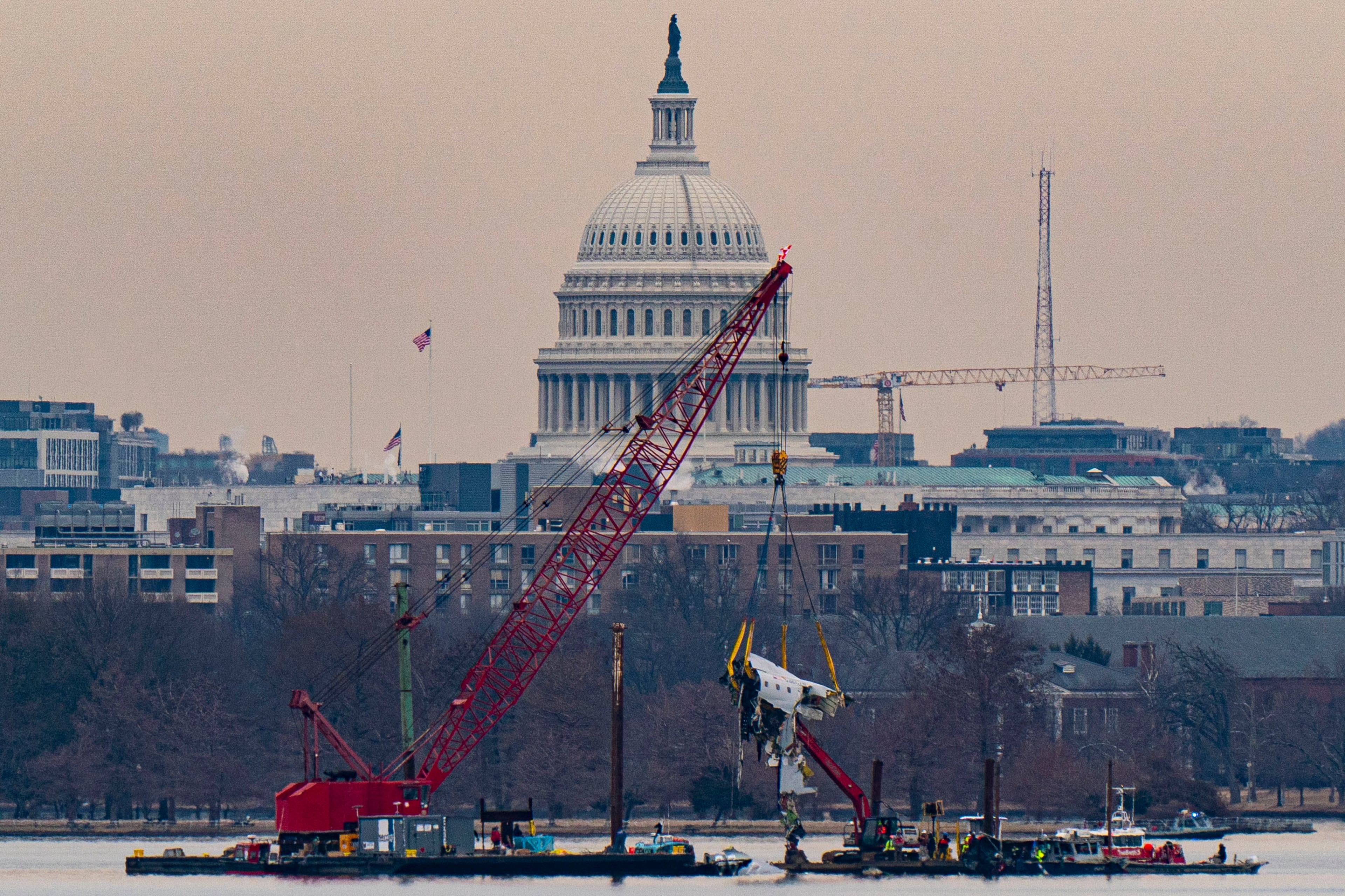 With the Capitol Building in the background, a crane lifts part of the fuselage from the wreckage of an American Airlines plane that crashed the night of Jan. 29, 2025, after a collision with a Black Hawk helicopter on the Potomac River in Arlington, Virginia. (Al Drago/The New York Times)
