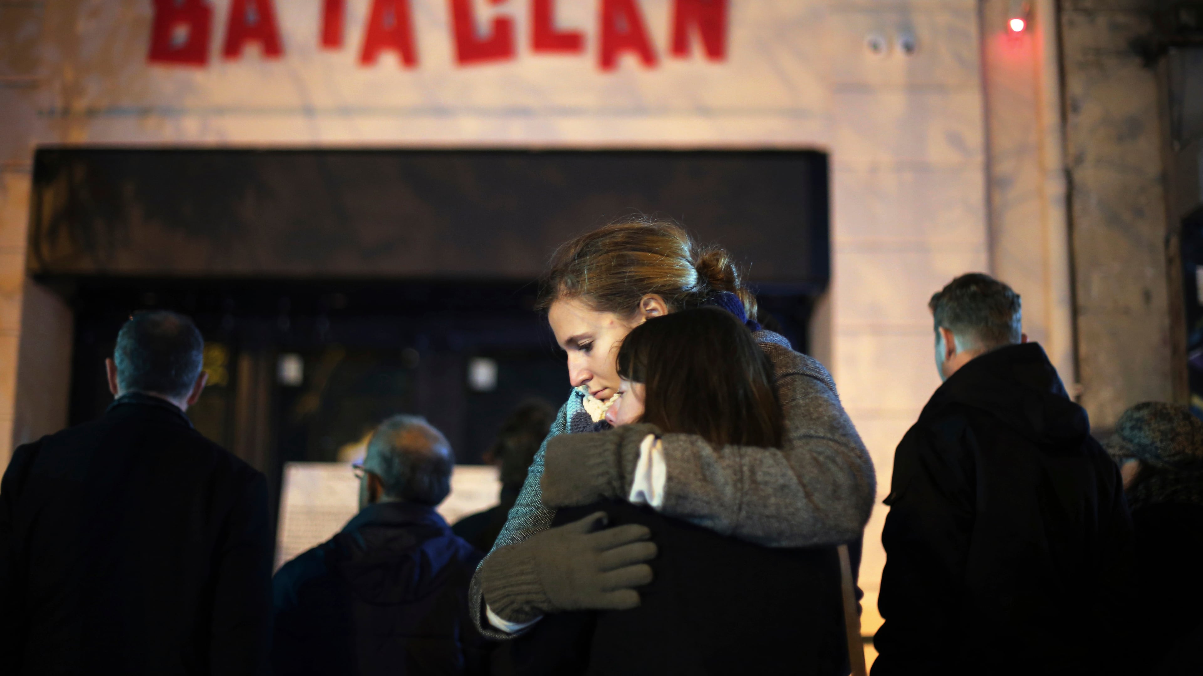 FILE - Women hug in front of the Bataclan concert hall in Paris on Nov. 13, 2016 . (AP Photo/Thibault Camus, File)