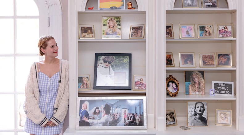 Molly Swindall stands with some of the autographed album covers in her collection of Taylor Swift memorabilia at her childhood home in Johns Creek. (MUST CREDIT: Kendrick Brinson for The Washington Post)