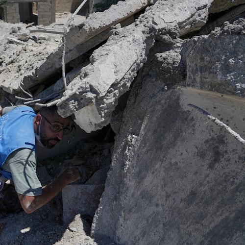 Rescue workers search for victims under the rubble of a destroyed building that was hit in an Israeli airstrike in Qannarit village, southern Lebanon, Saturday, June 20, 2026. (AP Photo/Mohammed Zaatari)