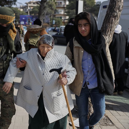 A Syrian government soldier helps an old woman who is fleeing from Sheikh Maqsoud and Achrafieh neighborhoods after clashes broke out on Tuesday between Syrian government forces and Kurdish fighters in a contested area of the northern city of Aleppo, Syria, Wednesday, Jan. 7, 2026. (AP Photo/Omar Albam)