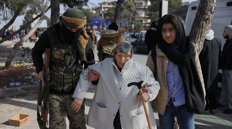 A Syrian government soldier helps an old woman who is fleeing from Sheikh Maqsoud and Achrafieh neighborhoods after clashes broke out on Tuesday between Syrian government forces and Kurdish fighters in a contested area of the northern city of Aleppo, Syria, Wednesday, Jan. 7, 2026. (AP Photo/Omar Albam)