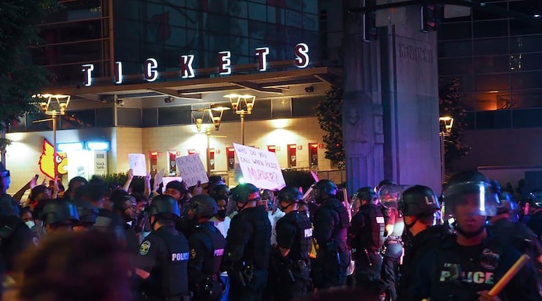 In this photo provided by the Instagram account of @mckinley_moore, police officers gather in downtown Louisville, Kentucky.