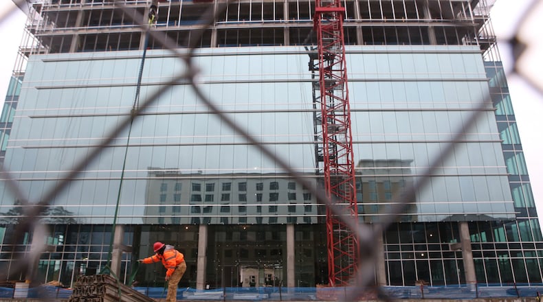 Steven Lonberg, a construction worker working at 4004 Summit Boulevard, assists a crane operator on March 13, 2017 as they build an office at 4004 Summit Boulevard in Brookhaven. It's being built with the help of $7.4 million in tax incentives from the DeKalb County Development Authority. (HENRY TAYLOR / HENRY.TAYLOR@AJC.COM)