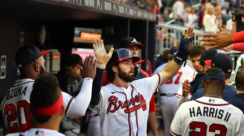 Braves shortstop Dansby Swanson gets high-fives in the dugout scoring on a RBI single by Austin Riley to take a 2-0 lead over the New York Mets during the third inning Thursday, August 18, 2022, in Atlanta.   “Curtis Compton / Curtis Compton@ajc.com