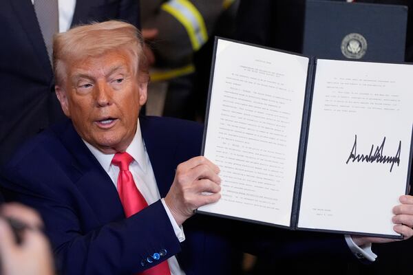 President Donald Trump holds a signed an executive order during an event in the East Room of the White House, Tuesday, April 8, 2025, in Washington. (AP Photo/Alex Brandon)