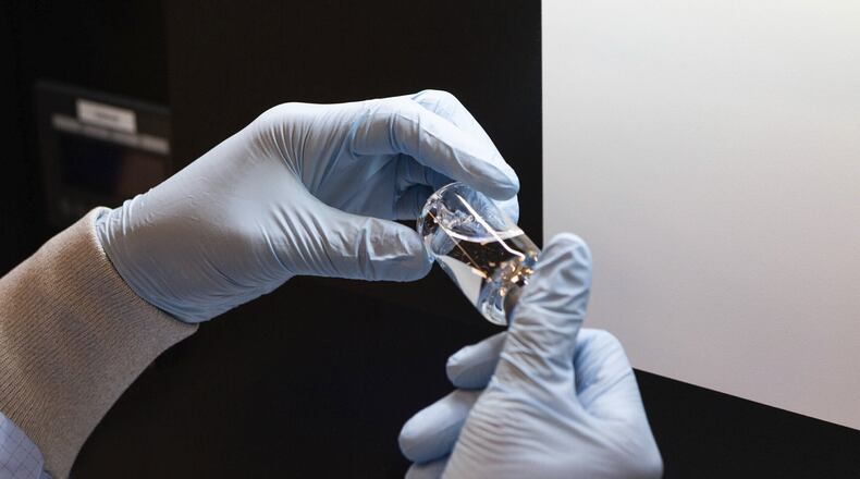 In this March 2020 photo provided by Gilead Sciences, a vial of the investigational drug remdesivir is visually inspected at a Gilead manufacturing site in the United States. Given through an IV, the medication is designed to interfere with an enzyme that reproduces viral genetic material. (Gilead Sciences via AP)