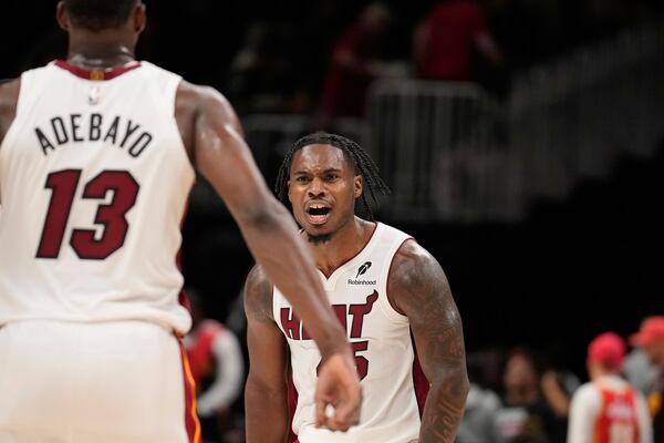 Miami Heat guard Davion Mitchell (45) celebrates with teammate Miami Heat center Bam Adebayo (13) in overtime of an NBA play-in tournament basketball game against the Atlanta Hawks, Friday, April 18, 2025, in Atlanta. (AP Photo/Brynn Anderson)