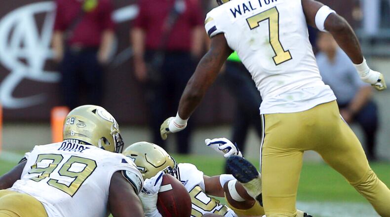 Georgia Tech defenders D'Quan Douse (99), Clayton Powell-Lee (29) and Zamari Walton help recover a fumble to seal the win against Virginia Tech. (Matt Gentry/The Roanoke Times via AP)