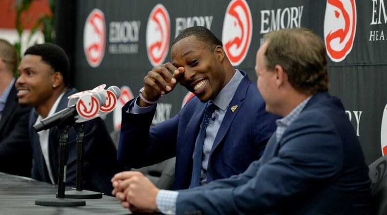July 13, 2016 Atlanta: Dwight Howard jokes about becoming emotional during a news conference, introducing him as the newest member of the Atlanta Hawks Wednesday July 13, 2016. Howard, an Atlanta native became emotional when he started talking about returning to Atlanta and playing for his hometown Atlanta Hawks. Head coach Mike Budenholzer is shown in the foreground. Howard will wear the number 8 in Atlanta, giving up the number he has worn most of his career, 12, The press event was held at the William Walker Recreation Center in SW Atlanta. The Hawks organization recently refurbished the basketball court at the Center as part of an ongoing community program. Howard played there as a youngster growing up in Atlanta. BRANT SANDERLIN/BSANDERLIN@AJC.COM