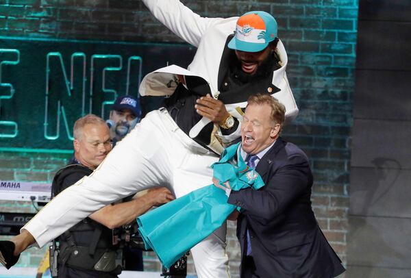 FILE - Clemson defensive tackle Christian Wilkins moves into NFL Commissioner Roger Goodell after the Miami Dolphins selected Wilkins in the first round at the NFL football draft in Nashville, Tenn. (AP Photo/Steve Helber, File)