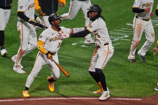 Pittsburgh Pirates' Andrew McCutchen, left, is retrained by Oneil Cruz as benches cleared after Washington Nationals pitcher Jorge López nearly hit McCutchen with a high inside pitch during the seventh inning of a baseball game in Pittsburgh, Wednesday, April 16, 2025. (AP Photo/Gene J. Puskar)
