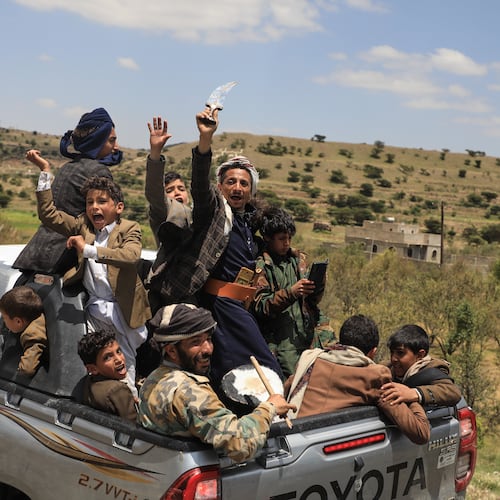 Yemeni civilians celebrate while riding in the back of a pickup truck in the Bani Matar district, Yemen, Saturday, Sept. 12, 2026, as they follow a convoy carrying Houthi prisoners freed in Mokha on its way to Sanaa following the Houthi takeover of the southern Red Sea port city. (AP Photo/STR)