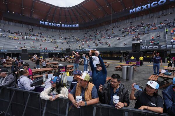 Fans take photos of NASCAR Mexico cars prior to a practice session for the NASCAR Cup Series auto race at Hermanos Rodriguez race track in Mexico City, Friday, June 13, 2025. (AP Photo/Fernando Llano)