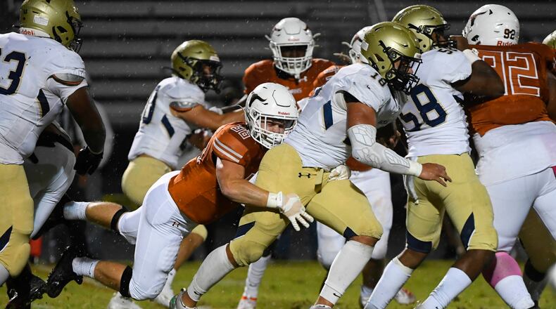 Dacula's Kyle Efford (18) rushes as Lanier's Ford Reasons (36) hangs on during Friday's game.